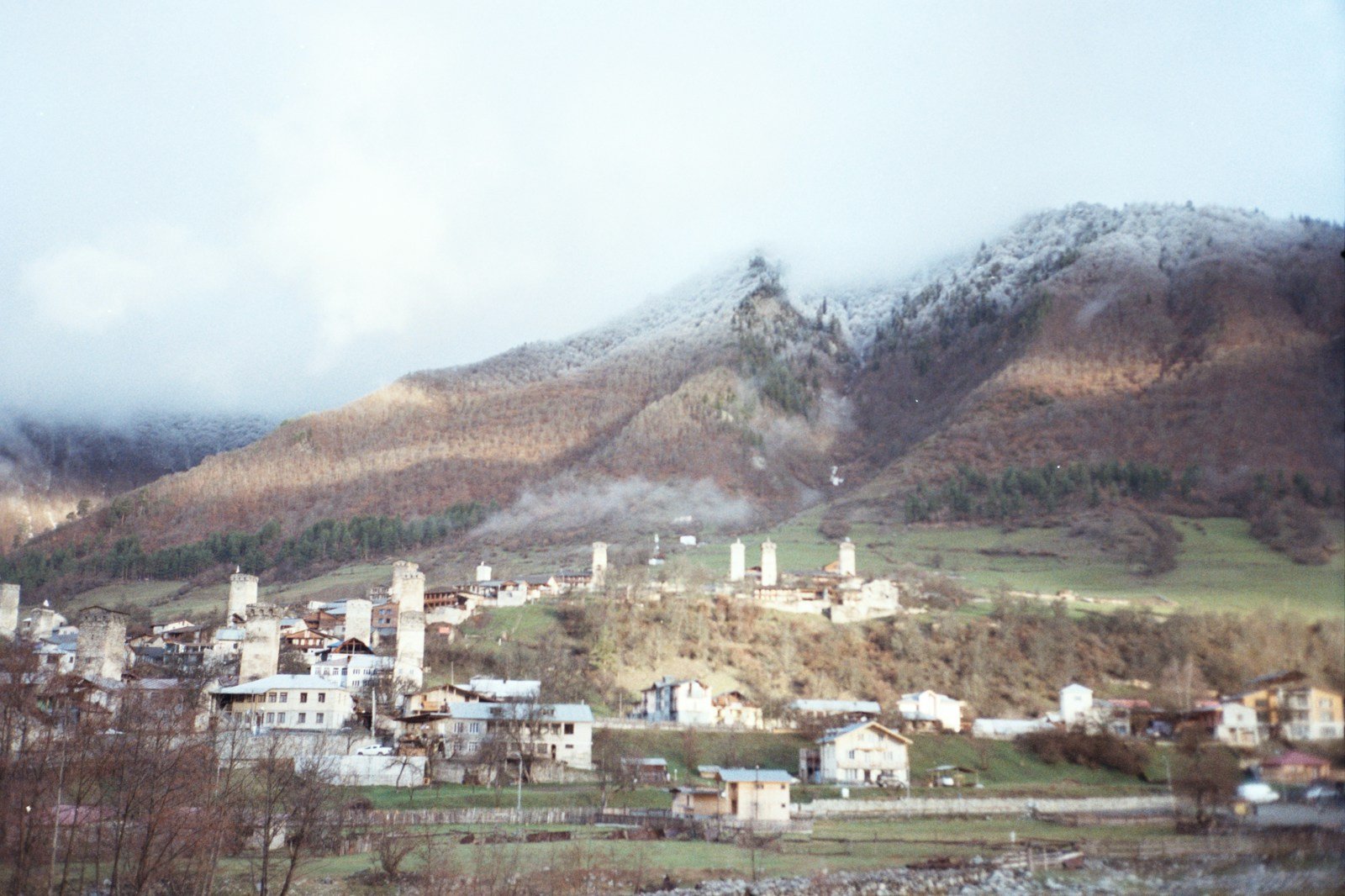 A town on a hill with a mountain in the background