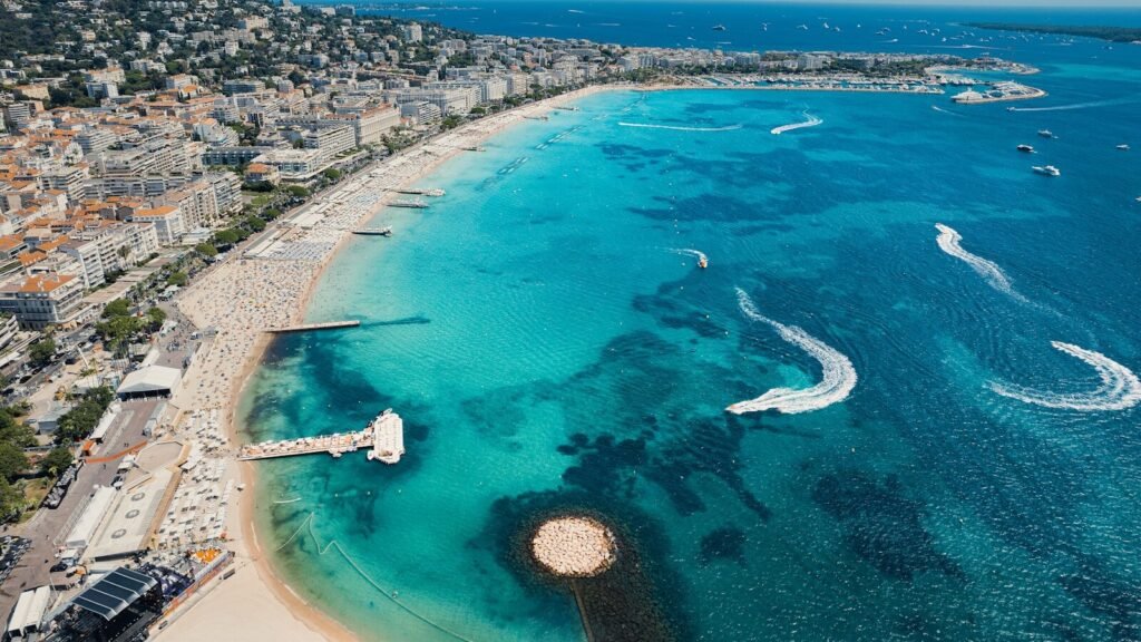 an aerial view of a beach with boats in the water